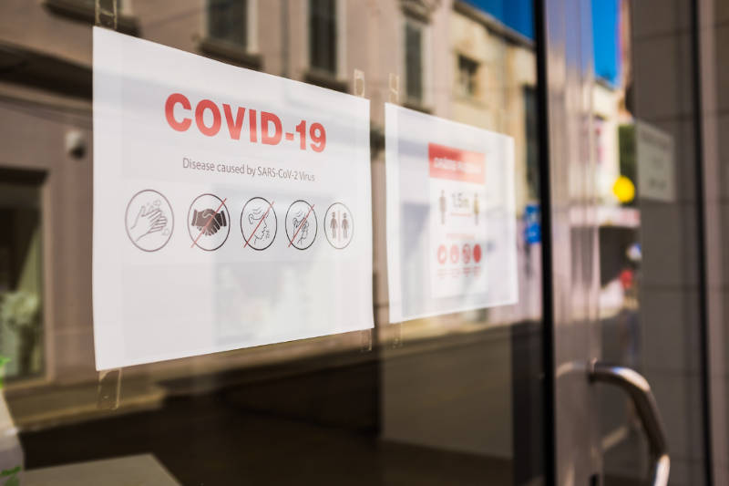 window with covid-19 signs